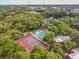 An aerial view of a community pool with a fountain pond and tennis courts nearby at 706 1St Ct, Palm Harbor, FL 34684
