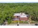 Aerial view of a charming condo with a terracotta roof, surrounded by trees and a pond at 706 1St Ct, Palm Harbor, FL 34684