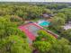 Overhead shot of community tennis courts and pool area surrounded by mature trees at 706 1St Ct, Palm Harbor, FL 34684