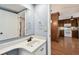 A bathroom sink has wood look flooring and a doorway to the kitchen at 706 1St Ct, Palm Harbor, FL 34684