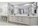 Bright bathroom featuring double sinks, a vanity with storage, vanity lighting and decorative mirrors at 706 1St Ct, Palm Harbor, FL 34684
