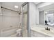 This bathroom has a tub with white tile, a light gray wall color, and a white vanity at 706 1St Ct, Palm Harbor, FL 34684