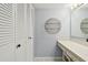 Bathroom featuring vanity, storage, updated lighting, and a decorative round shelf at 706 1St Ct, Palm Harbor, FL 34684