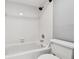 This white tiled bath and shower is clean and ready for a new owner at 706 1St Ct, Palm Harbor, FL 34684