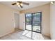 Cozy bedroom with tile flooring, ceiling fan and sliding glass door leading to outdoor patio at 706 1St Ct, Palm Harbor, FL 34684