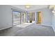 The carpeted bedroom has sliding glass doors, closet with mirrored doors and a ceiling fan at 706 1St Ct, Palm Harbor, FL 34684