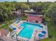 A sparkling community pool with ample seating and a hot tub under clear skies at 706 1St Ct, Palm Harbor, FL 34684