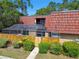 View of a property featuring a terracotta tiled roof and a screened in porch at 706 1St Ct, Palm Harbor, FL 34684