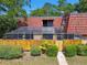 Property featuring a terracotta tiled roof, upper balcony, and a screened in porch at 706 1St Ct, Palm Harbor, FL 34684
