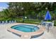Relaxing community hot tub featuring a tiled exterior, handrails, and shaded seating area at 706 1St Ct, Palm Harbor, FL 34684