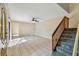 Bright living room featuring tiled floors, ceiling fan, staircase and a front door at 706 1St Ct, Palm Harbor, FL 34684