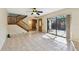 Open living area with tiled floors, staircase, and sliding glass doors to outdoor patio at 706 1St Ct, Palm Harbor, FL 34684