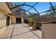 This patio has light colored tile, a potted palm, and is fully screened at 706 1St Ct, Palm Harbor, FL 34684