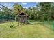 Community playground with swings, slide, and playhouse amidst green grass and shady trees at 706 1St Ct, Palm Harbor, FL 34684