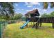 Community playground featuring a playhouse with a slide and swings, perfect for outdoor fun at 706 1St Ct, Palm Harbor, FL 34684