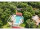 Aerial view of a community pool and tennis courts nestled in mature landscaping at 706 1St Ct, Palm Harbor, FL 34684