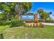 Well-maintained community sign with colorful flowers and plants at 706 1St Ct, Palm Harbor, FL 34684