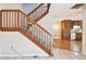Carpeted staircase featuring wood banister, with partial view of a kitchen and living room at 706 1St Ct, Palm Harbor, FL 34684