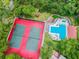Aerial view of tennis courts and community pool surrounded by mature landscaping at 706 1St Ct, Palm Harbor, FL 34684