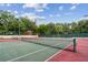 Red and green tennis courts surrounded by mature trees at 706 1St Ct, Palm Harbor, FL 34684