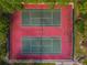 Aerial shot showcasing well-maintained tennis courts with vibrant red and green surfaces at 706 1St Ct, Palm Harbor, FL 34684