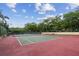 Red and green tennis courts surrounded by mature trees at 706 1St Ct, Palm Harbor, FL 34684