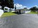 Features a backyard with a covered patio and asphalt parking area, ideal for gatherings at 7102 Reindeer Rd, Tampa, FL 33619