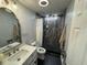 This bathroom has a black tiled shower, vanity, and updated fixtures at 7102 Reindeer Rd, Tampa, FL 33619