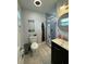 This bathroom features a black vanity, a black and white accent wall, a shower, and a toilet at 7102 Reindeer Rd, Tampa, FL 33619