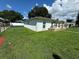 Shows the home's clean, white exterior and neatly kept lawn, framed by a modern fence at 7102 Reindeer Rd, Tampa, FL 33619
