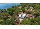 Aerial view of a property with solar panels near a waterfront location and surrounded by lush trees at 7235 Sunshine S Dr, St Petersburg, FL 33705