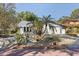 Inviting single-story home featuring a beautiful yard with native plants, rocks, and a paved driveway at 7235 Sunshine S Dr, St Petersburg, FL 33705