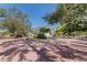 Landscaped front exterior featuring a well-maintained lawn, mature trees, and circular driveway at 7235 Sunshine S Dr, St Petersburg, FL 33705