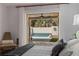 Warm bedroom featuring a view of the pool, access to patio and a cushioned chair at 7235 Sunshine S Dr, St Petersburg, FL 33705