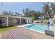 Backyard pool and deck area with a wooden deck and covered patio perfect for outdoor entertaining and relaxation at 7235 Sunshine S Dr, St Petersburg, FL 33705