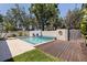 Private pool area featuring a built-in water feature, wooden deck, and lush landscaping at 7235 Sunshine S Dr, St Petersburg, FL 33705