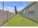 Side view of the property with an enclosed sunroom, fenced perimeter, and well-maintained grassy area at 7246 Julian St, New Port Richey, FL 34653