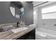 Well-lit bathroom features a granite countertop, a vessel sink, tub and shower combination and a modern color palette at 7246 Julian St, New Port Richey, FL 34653