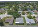 Wide aerial perspective of a community with mature trees, a pond, and varied home styles at 7246 Julian St, New Port Richey, FL 34653