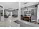 A combined living and dining room boasts white tile floors and a modern chandelier above a black dining set at 7246 Julian St, New Port Richey, FL 34653