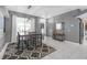Bright dining area with a modern chandelier and access to the home's entrance, enhanced by white tile floors at 7246 Julian St, New Port Richey, FL 34653