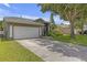Charming single-story home featuring a two-car garage, well-manicured lawn, and mature shade tree at 7246 Julian St, New Port Richey, FL 34653