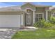 Charming home featuring a two-car garage, covered entry, and beautifully landscaped front yard at 7246 Julian St, New Port Richey, FL 34653