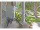Relaxing front porch has ornamental plants, columns and a quaint sitting area, enhancing curb appeal at 7246 Julian St, New Port Richey, FL 34653