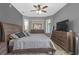 Comfortable main bedroom features a ceiling fan, gray walls, a decorative accent wall, and neutral furnishings at 7246 Julian St, New Port Richey, FL 34653