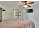 This bedroom has a flatscreen TV, ceiling fan, and a glass door to the patio at 728 Camrose Dr, Brandon, FL 33510