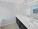 Bright bathroom featuring double sinks, a large mirror, and tile flooring at 8452 Silverbell Loop, Brooksville, FL 34613