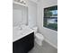 Modern bathroom with a sleek vanity, toilet, and well-lit mirror at 8452 Silverbell Loop, Brooksville, FL 34613