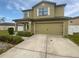 Two-story home featuring a two-car garage, neutral color scheme, and manicured landscaping for enhanced curb appeal at 8452 Silverbell Loop, Brooksville, FL 34613