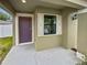 Inviting front porch with a colorful door and a window with decorative shutters at 8452 Silverbell Loop, Brooksville, FL 34613